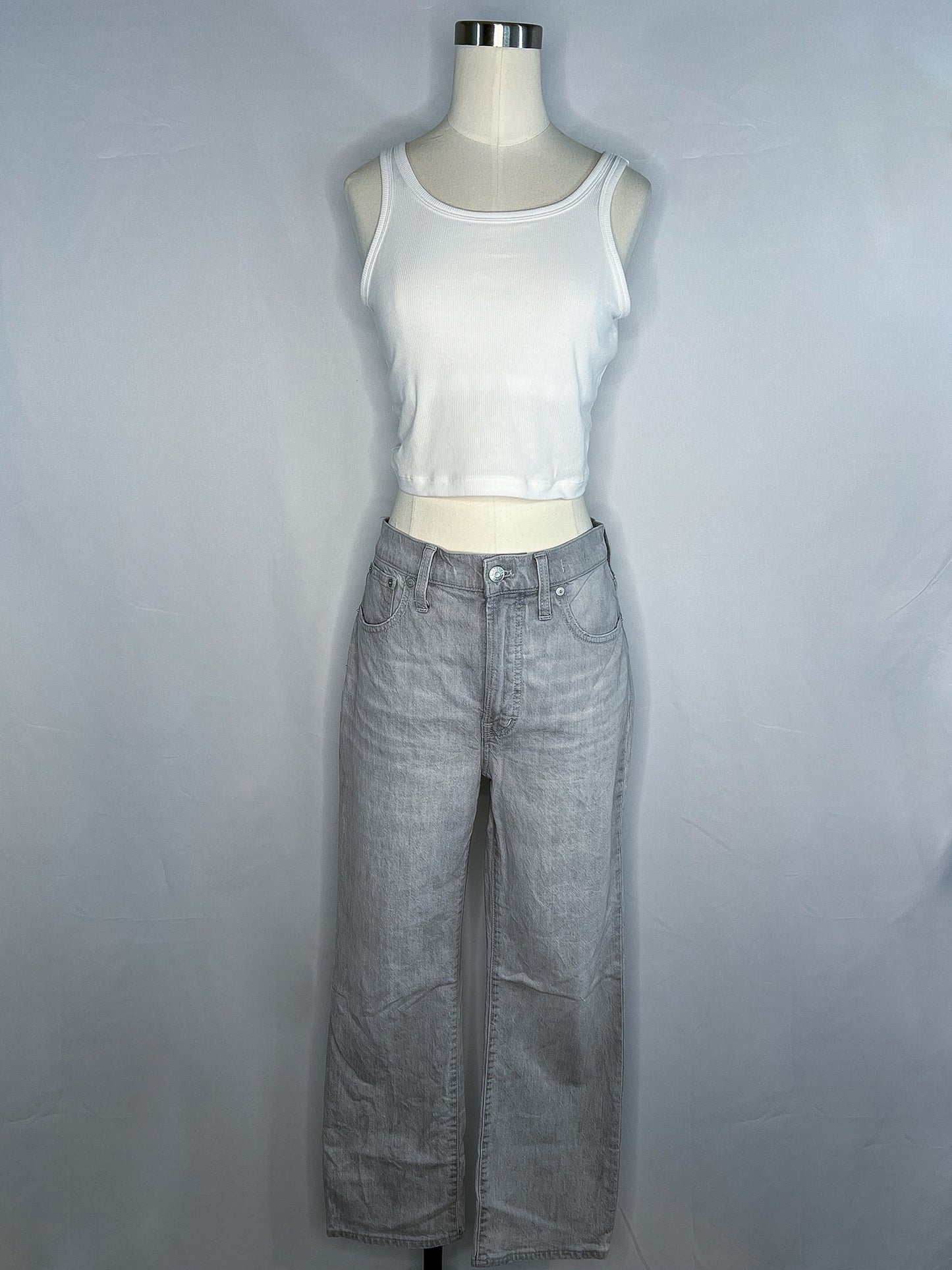 Front full length view of white crop top (shown for outfit purposes) and grey, Madewell slim demi-boot jeans