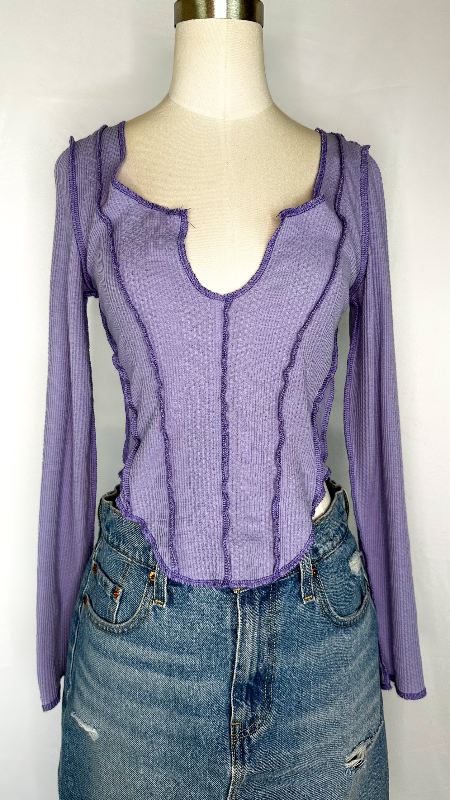 Front facing view of Urban Outfitters Long Sleeve Corset Style Top in Purple size medium. Featuring a v-neck, corset style stitching, and a scoop bottom hem.
