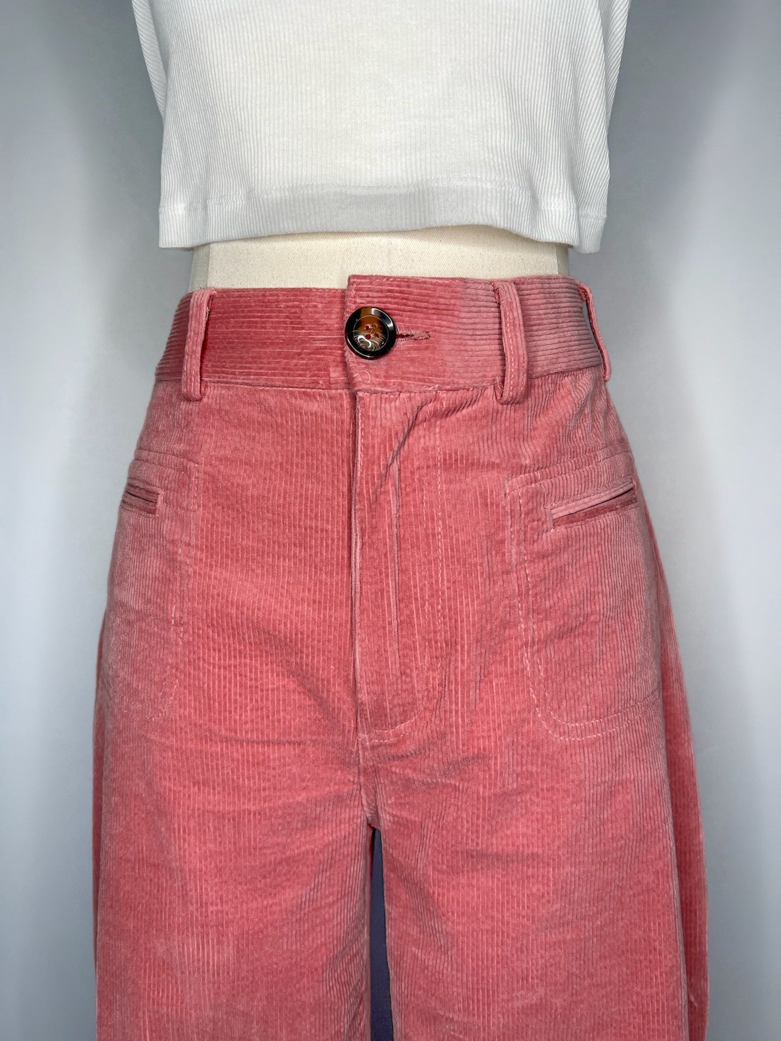 Close up of Saint Geraldine Wide-Leg Corduroy Pant in Pink, featuring the button, belt loops, and two front pockets.