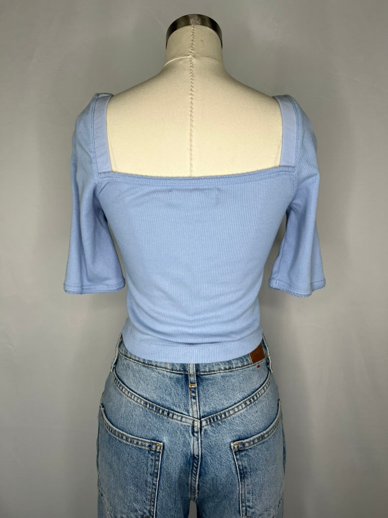 Back view of Urban Outfitters Square Neck Crop Top in Light Blue shown on a mannequin wearing light blue jeans and features the back side square neck line.