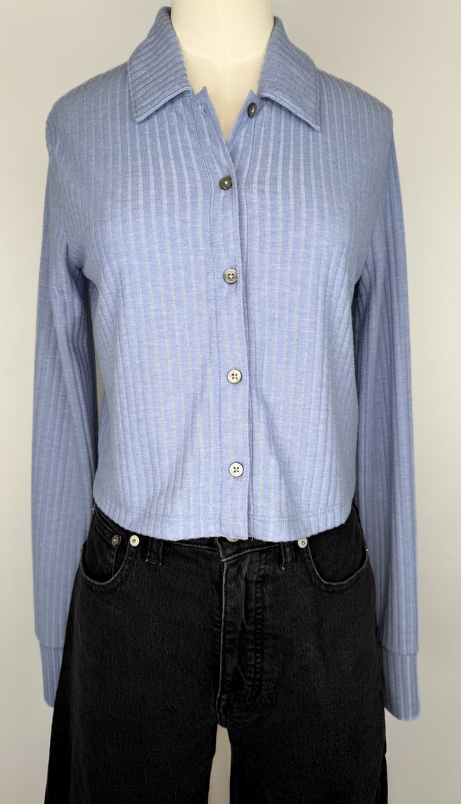 Front view of Periwinkle blue ribbed long-sleeve shirt on a mannequin with black jeans against a white background.