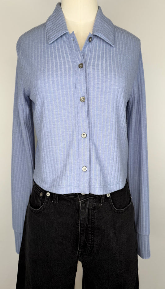 Front view of Periwinkle blue ribbed long-sleeve shirt on a mannequin with black jeans against a white background.