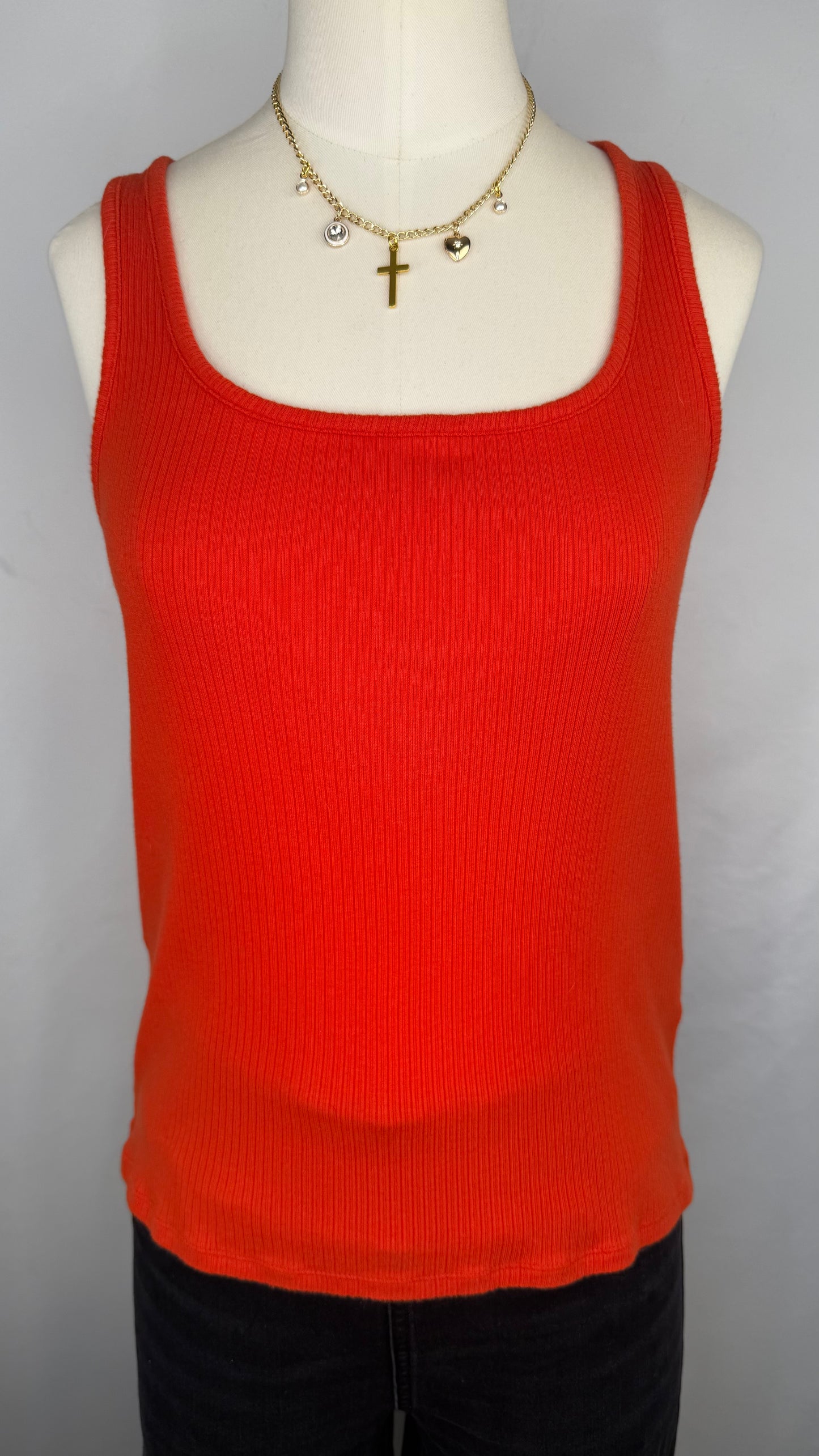 Front view of Madewell Ribbed Square-Neck Tank Top in Flame. The mannequin is shown wearing a gold chain charm necklace and black jeans.
