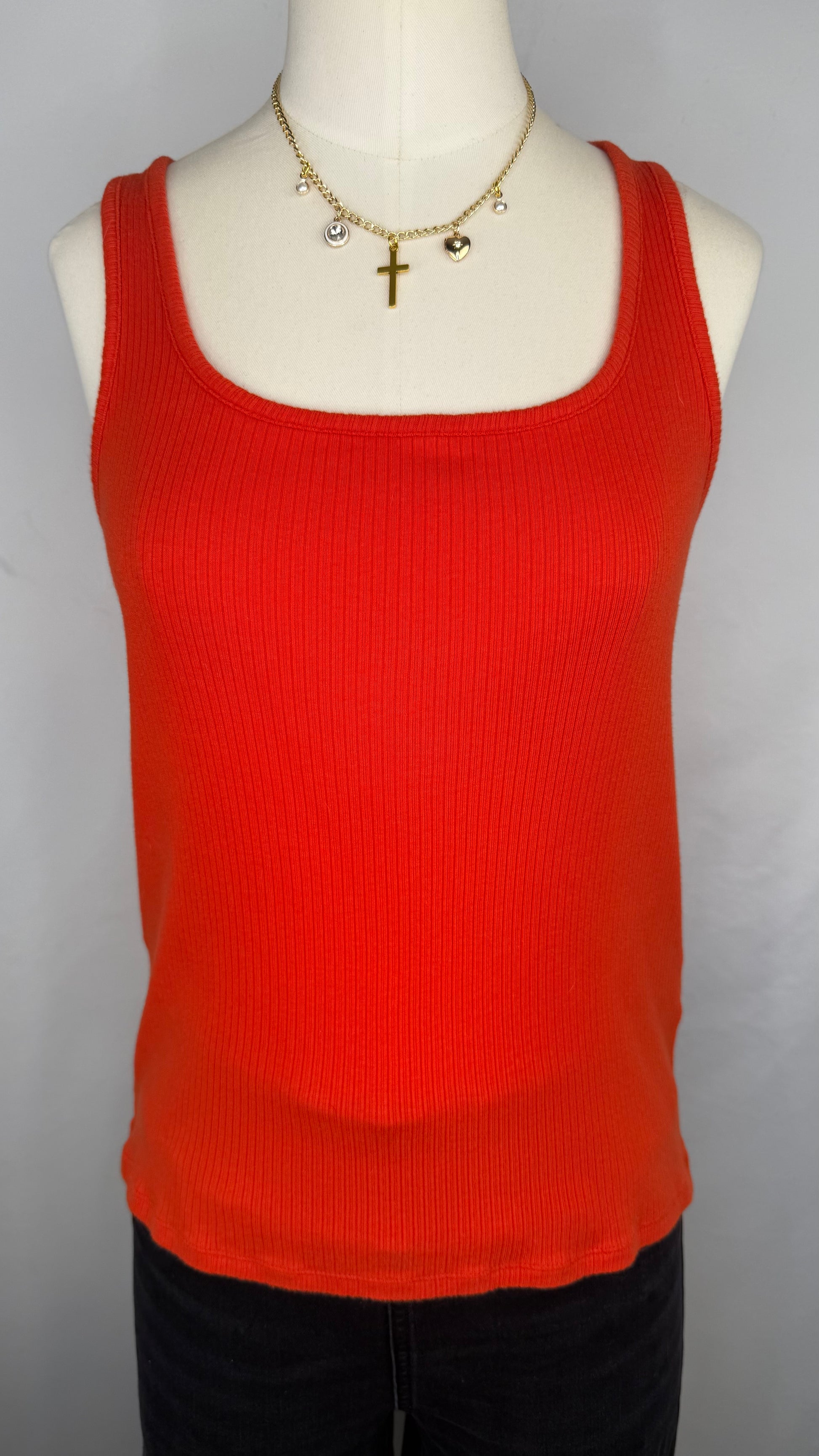 Front view of Madewell Ribbed Square-Neck Tank Top in Flame. The mannequin is shown wearing a gold chain charm necklace and black jeans.