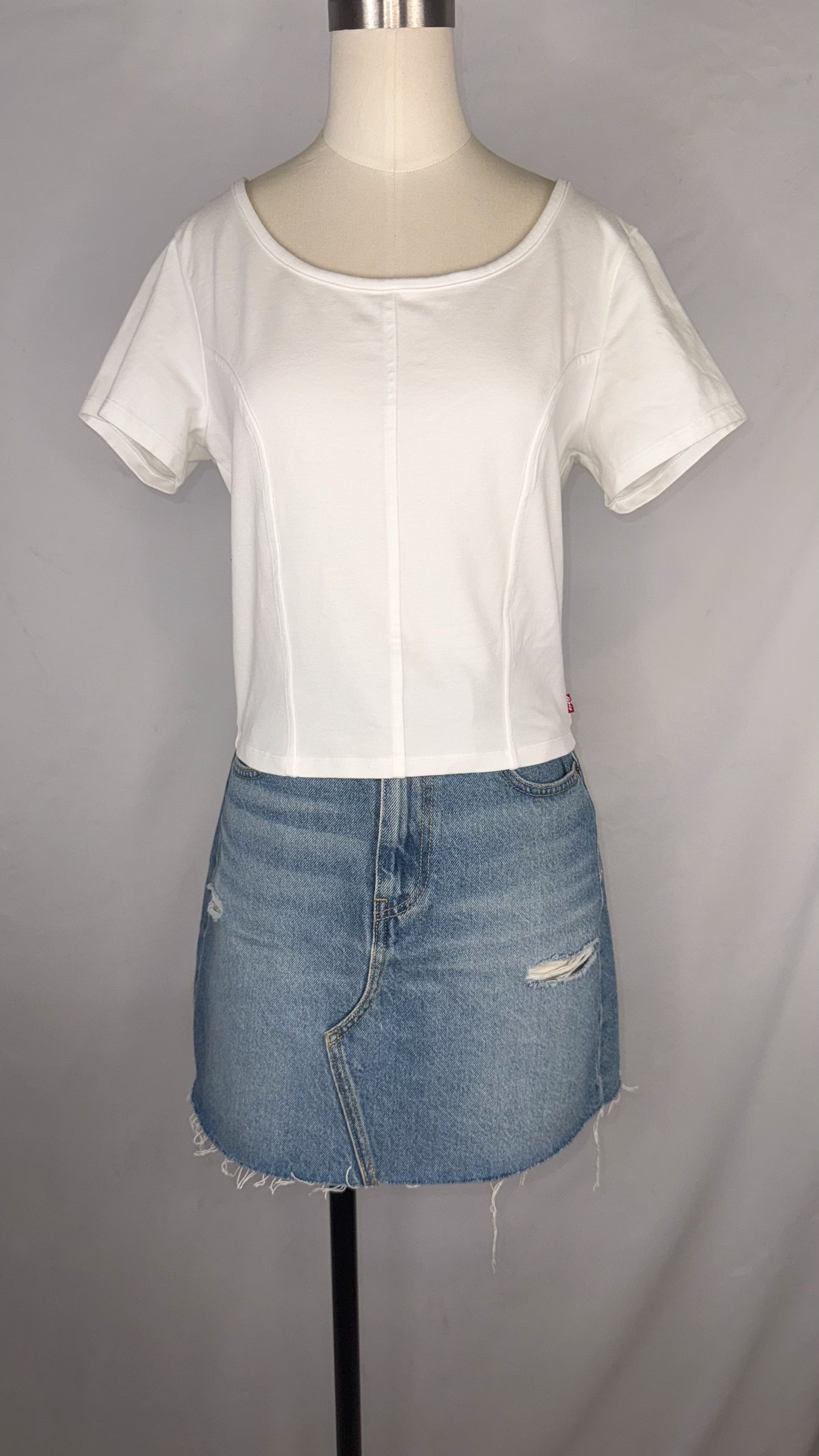 Front view of Levi's Corset T-Shirt in White size large with mannequin wearing the top paired with a light blue, distressed denim mini skirt.