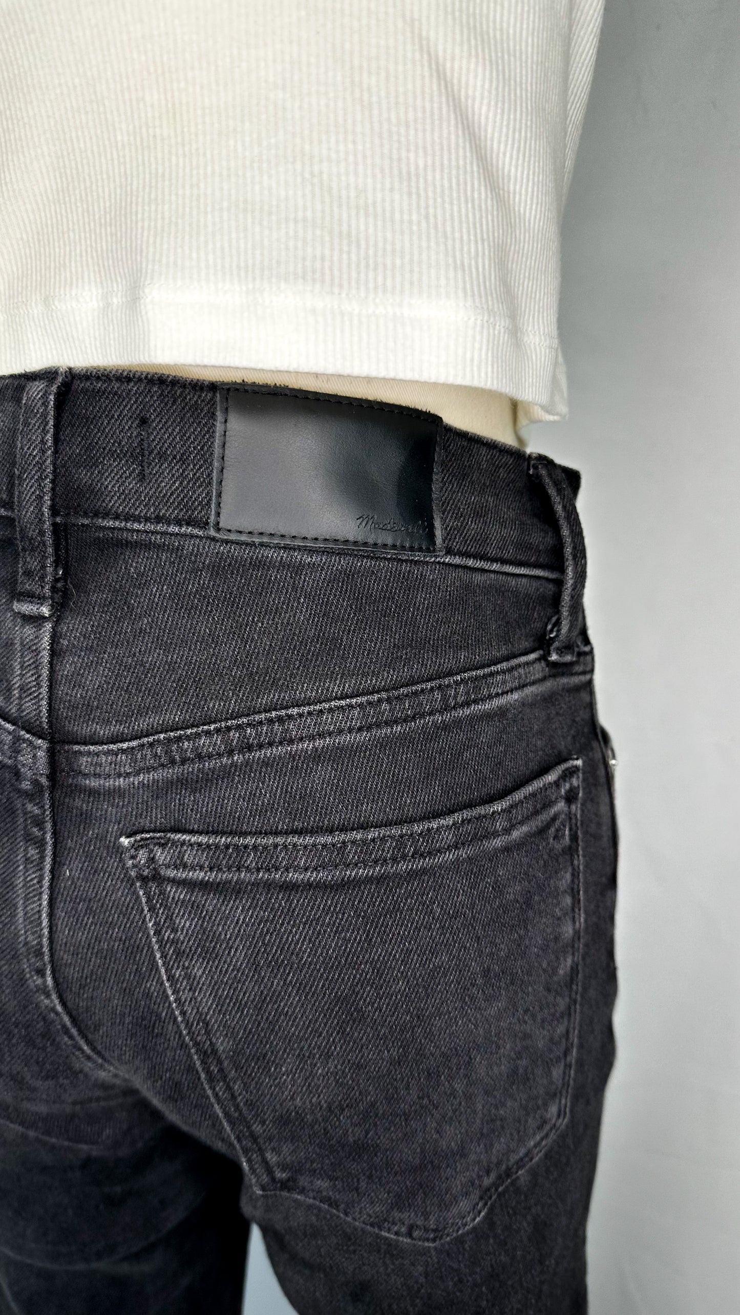 Up-close back view of Madewell Cali Demi-Boot Jeans in Starkey Wash, featuring the black Madewell leather tag and one of the back pockets.