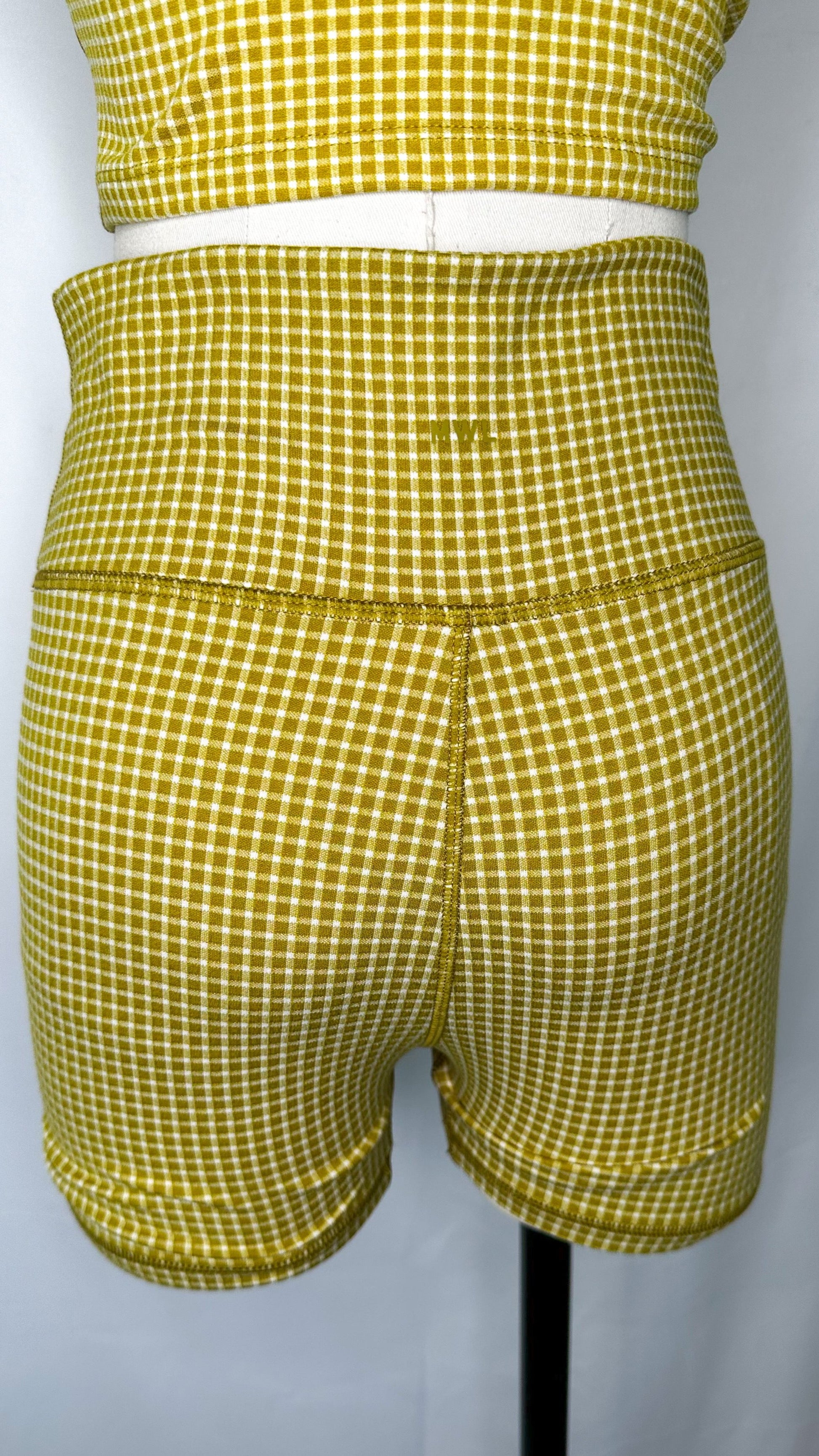 Back view of Madewell High Rise Biker Shorts in gingham print and citrus lime color, featuring the MWL logo.