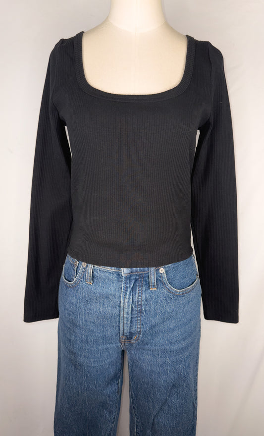 Front view of Madewell Square-Neck Long-Sleeve Crop Tee in True Black. Plain black long sleeve ribbed tee with a square neckline. The top is shown on the mannequin paired with a dark blue jean.