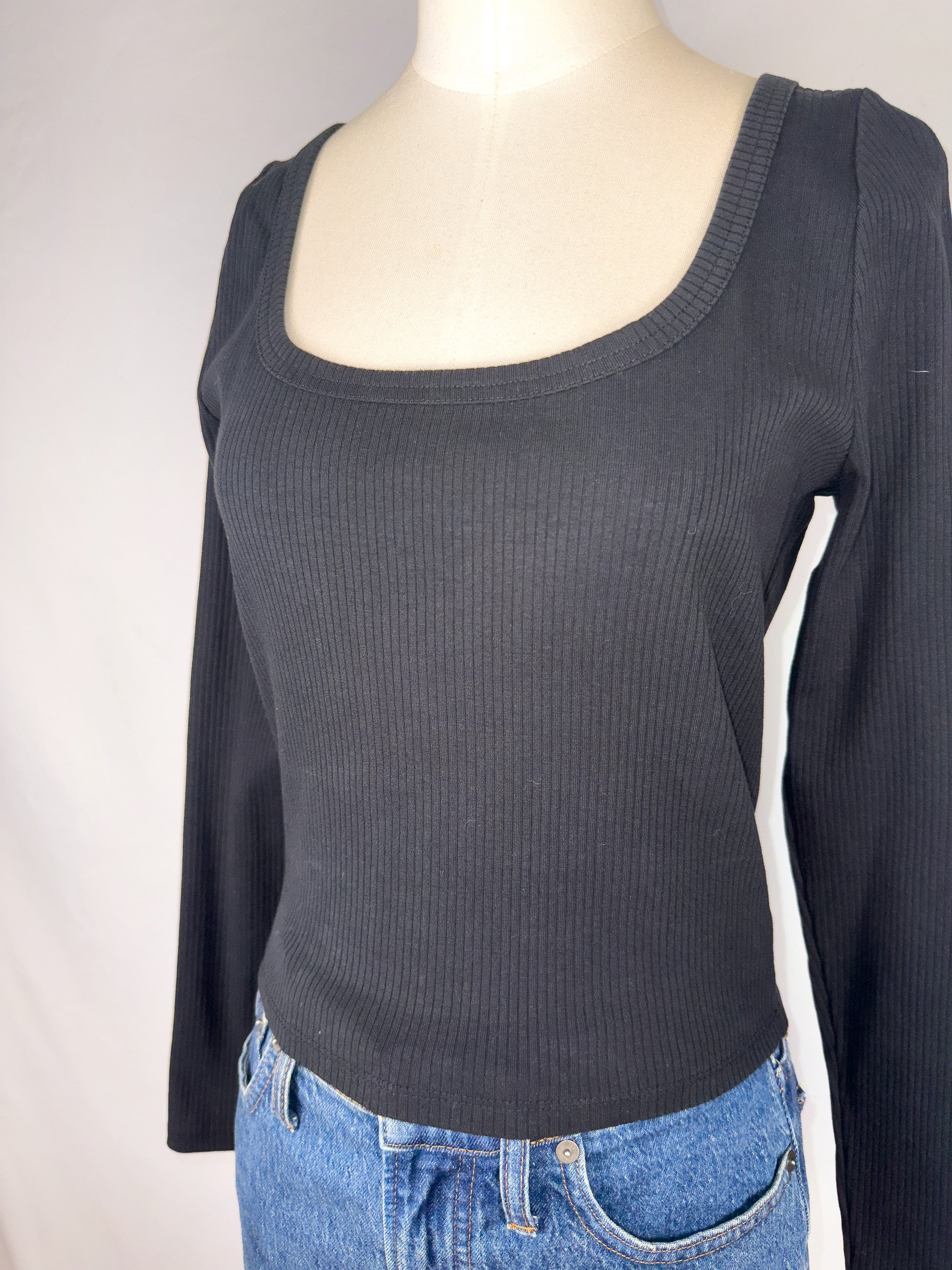 Up-close side view of Madewell Square-Neck Long-Sleeve Crop Tee in True Black. Highlighting the ribbed detailing on the shirt, as well as the square neckline.