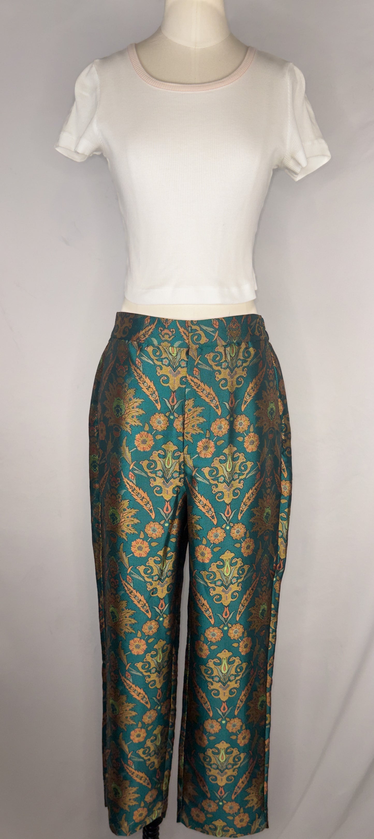 Front view of Maeve by Anthropologie Jacquard Trouser in Multi. The trousers are shown paired with a white, cropped tee. The trousers have a front hook closure and a button.