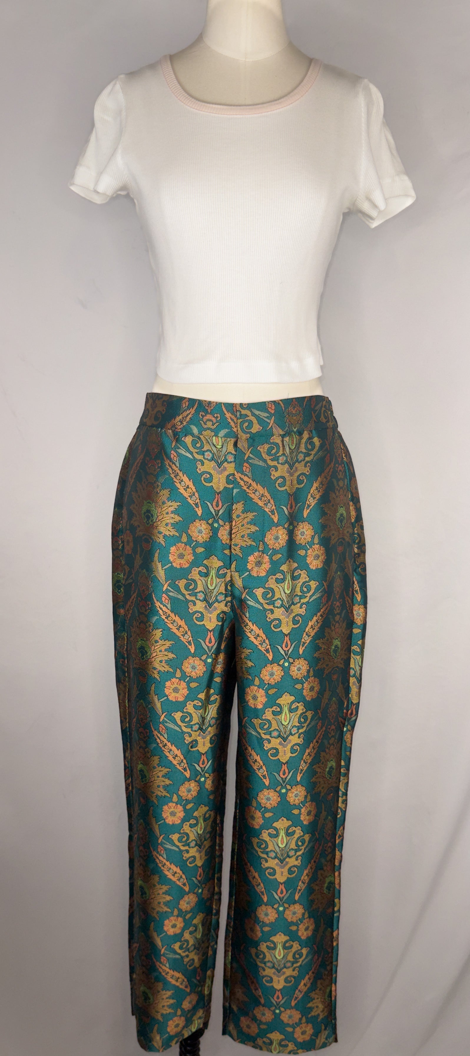 Front view of Maeve by Anthropologie Jacquard Trouser in Multi. The trousers are shown paired with a white, cropped tee. The trousers have a front hook closure and a button.