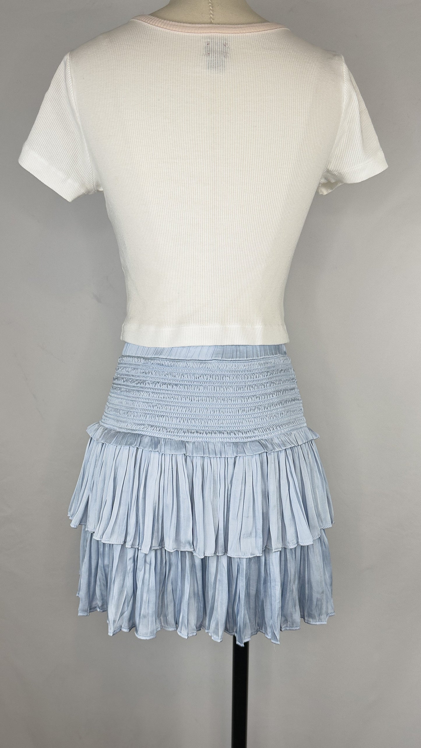 Back view of Reset By Jane Silky Smocked Skirt in Light Blue. The skirt is paired with a cropped white tea.