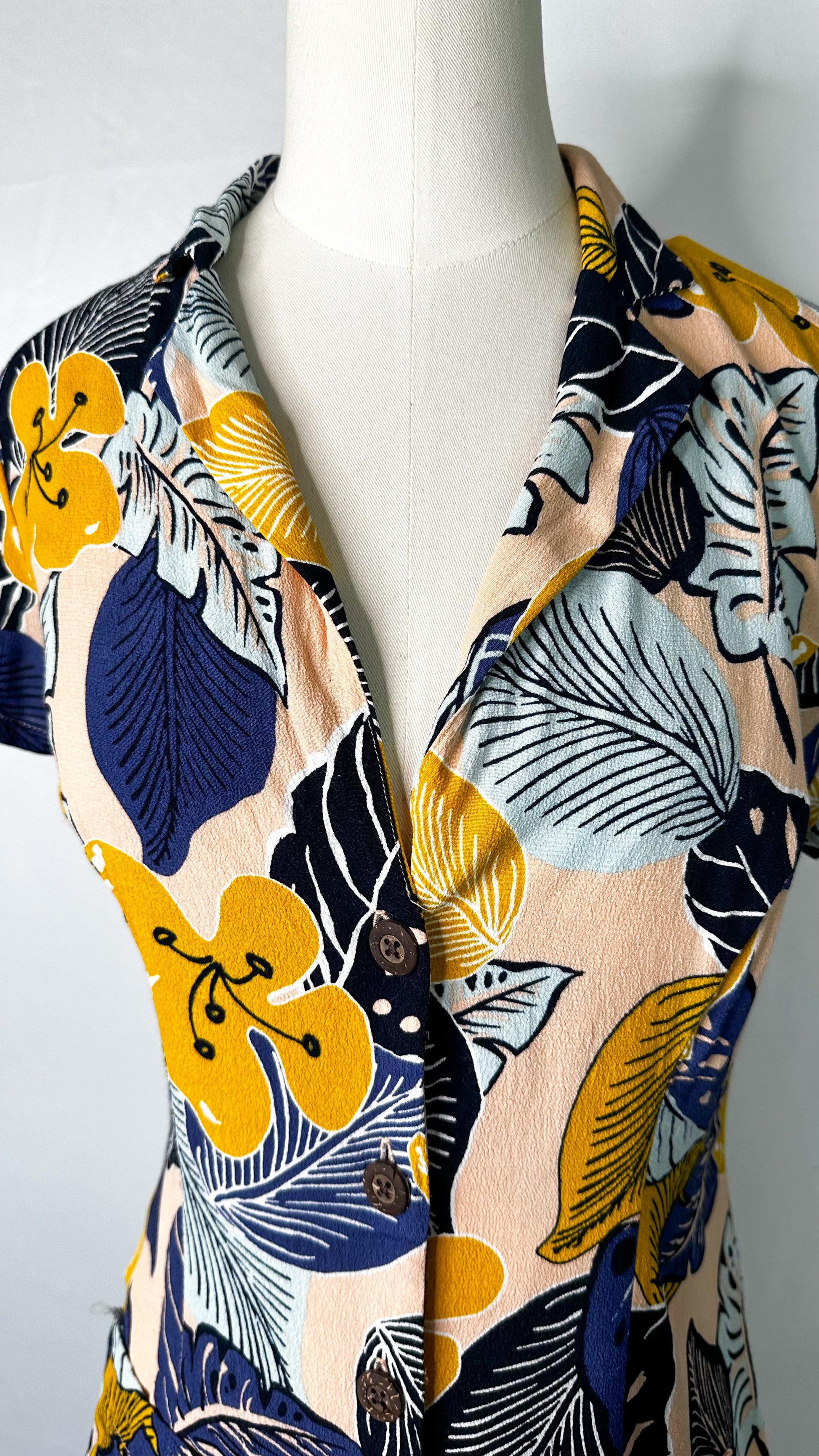 Up-close front view ofSilence + Noise Button-Down Mini Dress in Tropical Print, featuring the low-cut neckline and collar.
