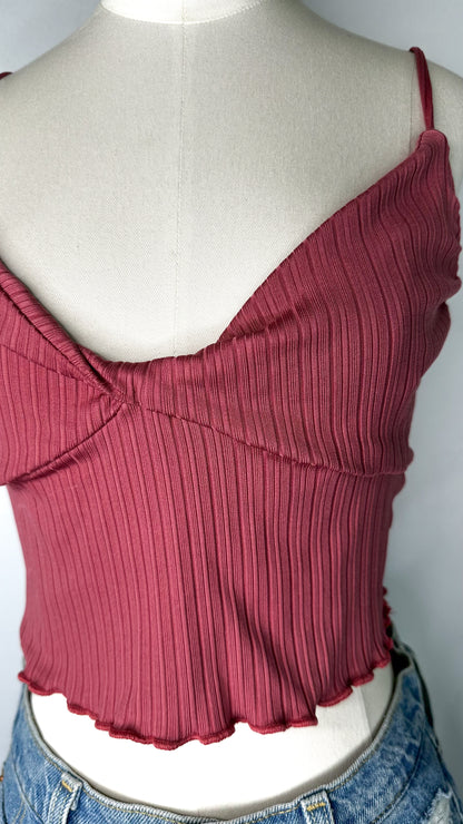 Up-close front view of Urban Outfitters Ribbed Twist Front Cami Top in Pink featuring the twist front and ribbed detailing, as well as the lettuce edge hem.